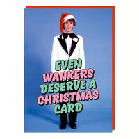 A Christmas card with a picture of a teenager dressed in a white 1970s prom tuxedo. Red and green text in front reads Even w*nkers deserve a Christmas card.