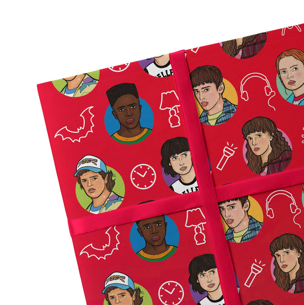 Stranger Things Wrapping Paper - 2 Sheets red paper with cartoonised depictions of the characters in a symmetrical pattern 